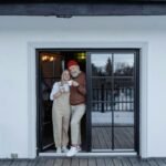 Happy senior couple enjoying coffee on their porch in winter.